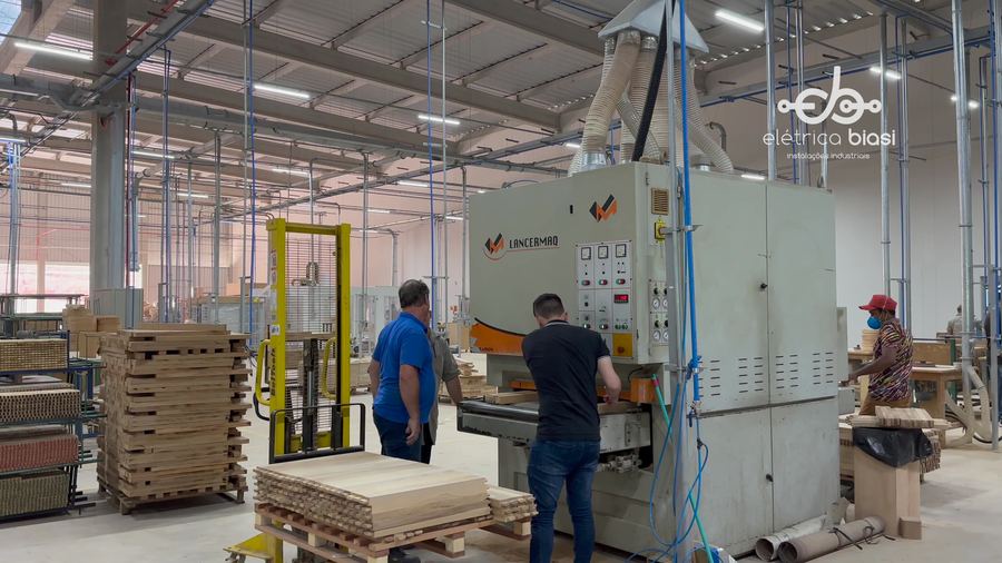 Fábrica com máquinas e equipe em operação